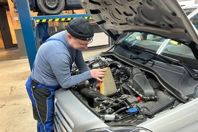 Mechaniker wechselt den Luftfilter im Motorraum